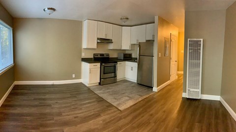 a kitchen with white cabinets and a stainless steel refrigerator